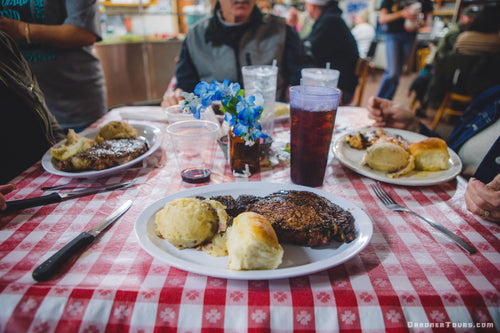 Close-up of a large steak plate sitting on a checkered table cloth at the Leona General Store in Leona, Texas.