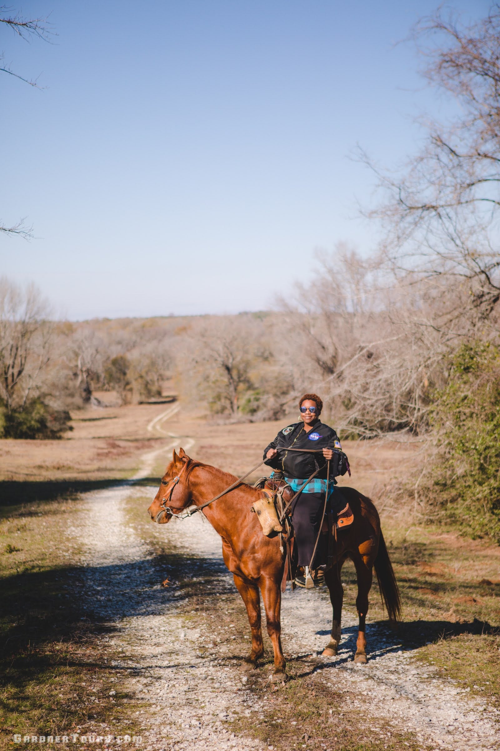 Woman riding a red horse on a ranch outside Centerville, Texas.