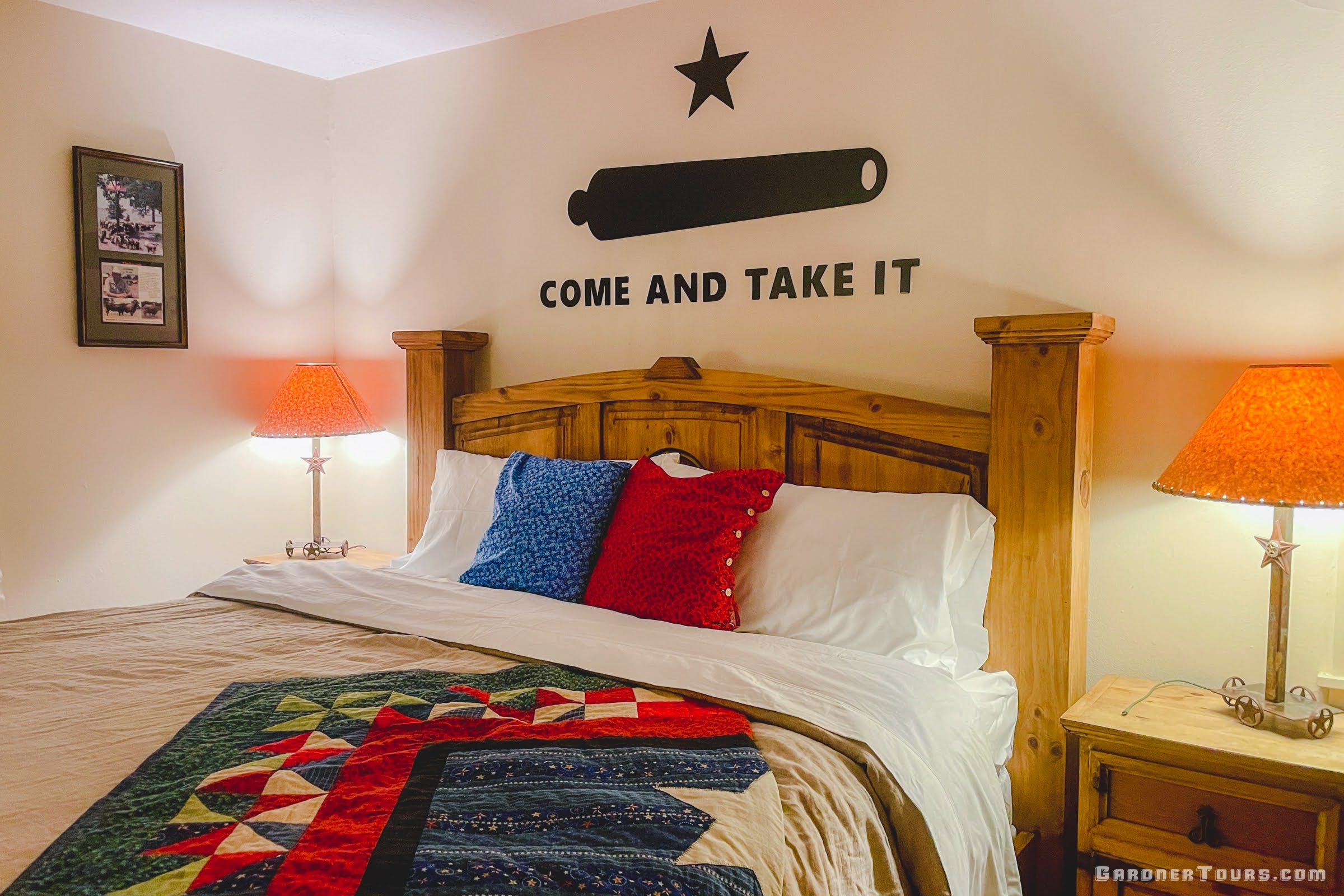 Texas Themed Bedroom with wooden headboard, colorful Texas Flag quilt, and 'Come and Take It' wall quote.