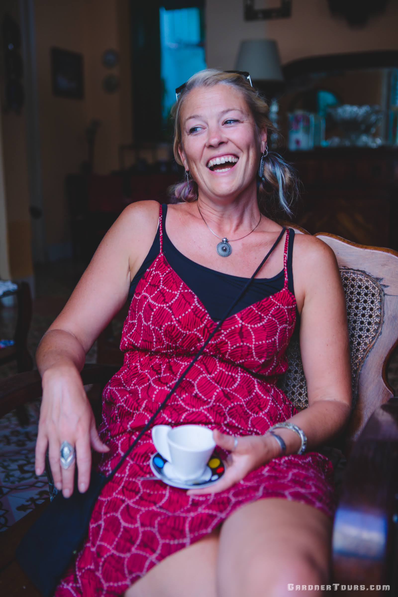 Woman in red dress laughing while enjoying a Cuban Coffee in the Morning in Cuba