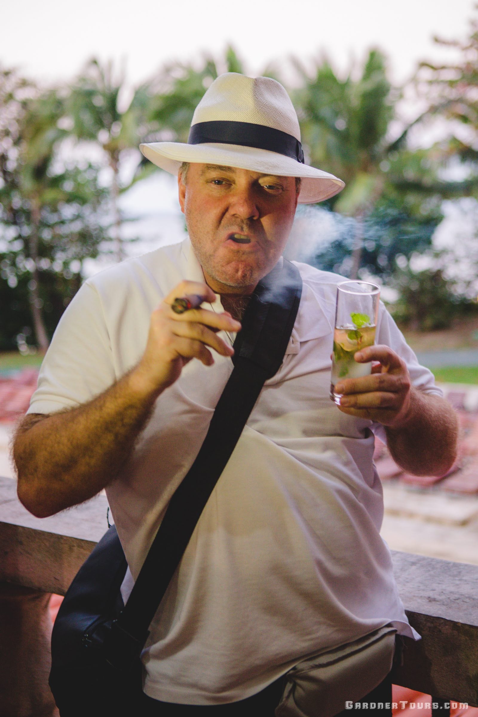 Man Smoking a Cigar and Drinking a Mojito looking like a Gangster at Hotel Nacional in Havana