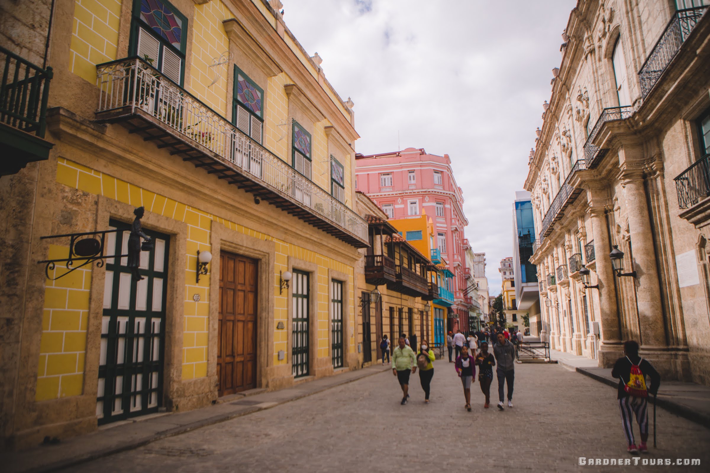 People Walking in the Streets with Yellow Painted Buildings of Old Havana, Cuba