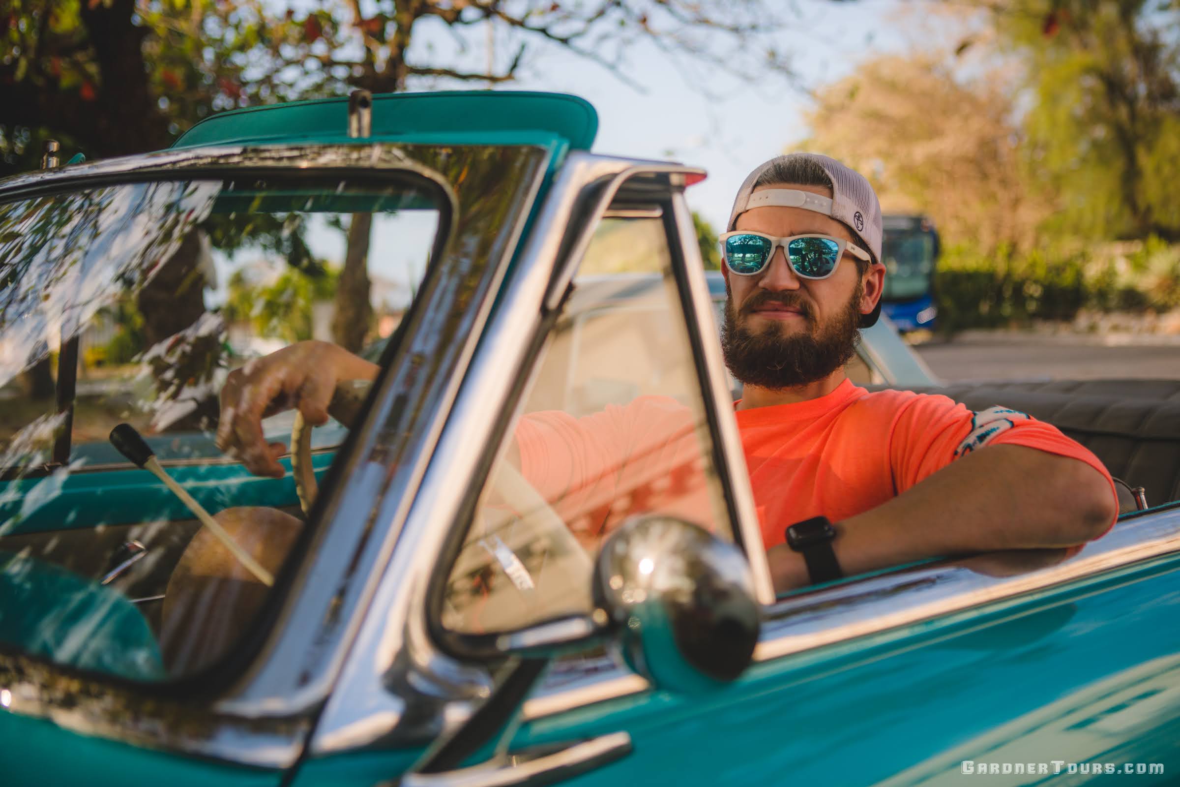 Man in Sunglasses Driving Classic American Car Convertible in Cuba
