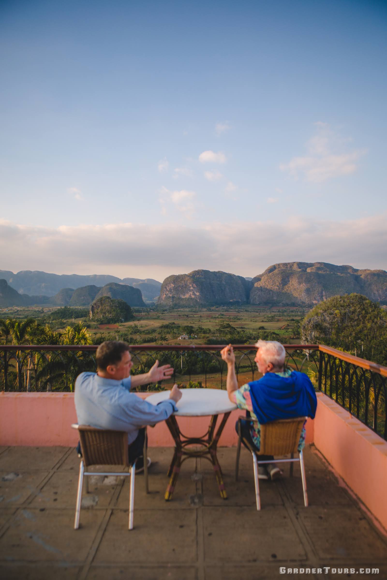 Two men smoking cigars and Enjoying the view of the Vinales Valley from the Hotel Los Jazmines Viewpoint in Vinales, Cuba